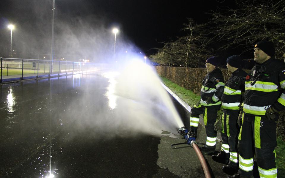 De brandweer van Bolsward spuit water op de skeelerbaan om er een schaatsbaan van te maken. Foto: Johan Vogelzang 
